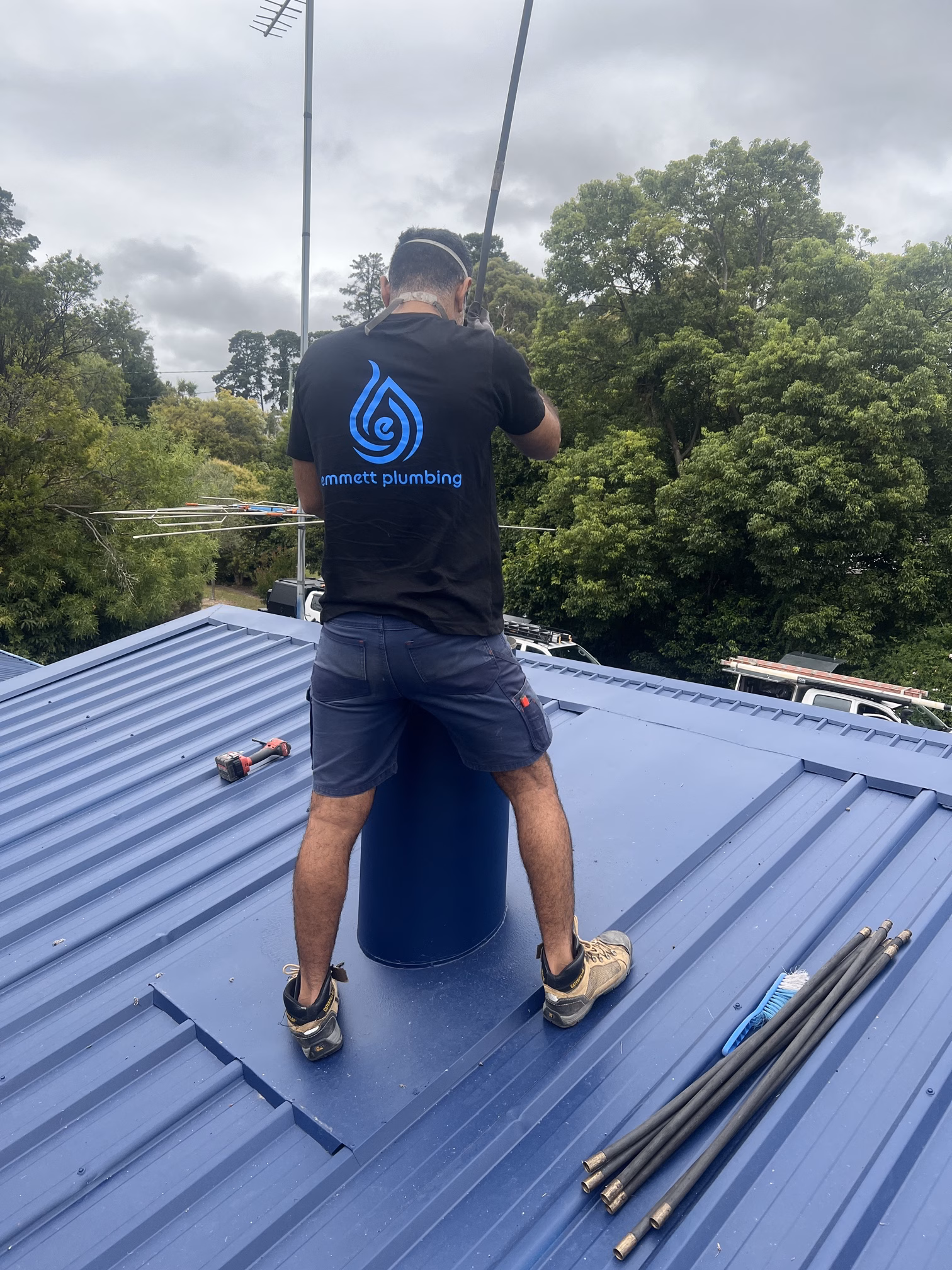 Emmett Plumbing technician sweeping a chimney from the roof