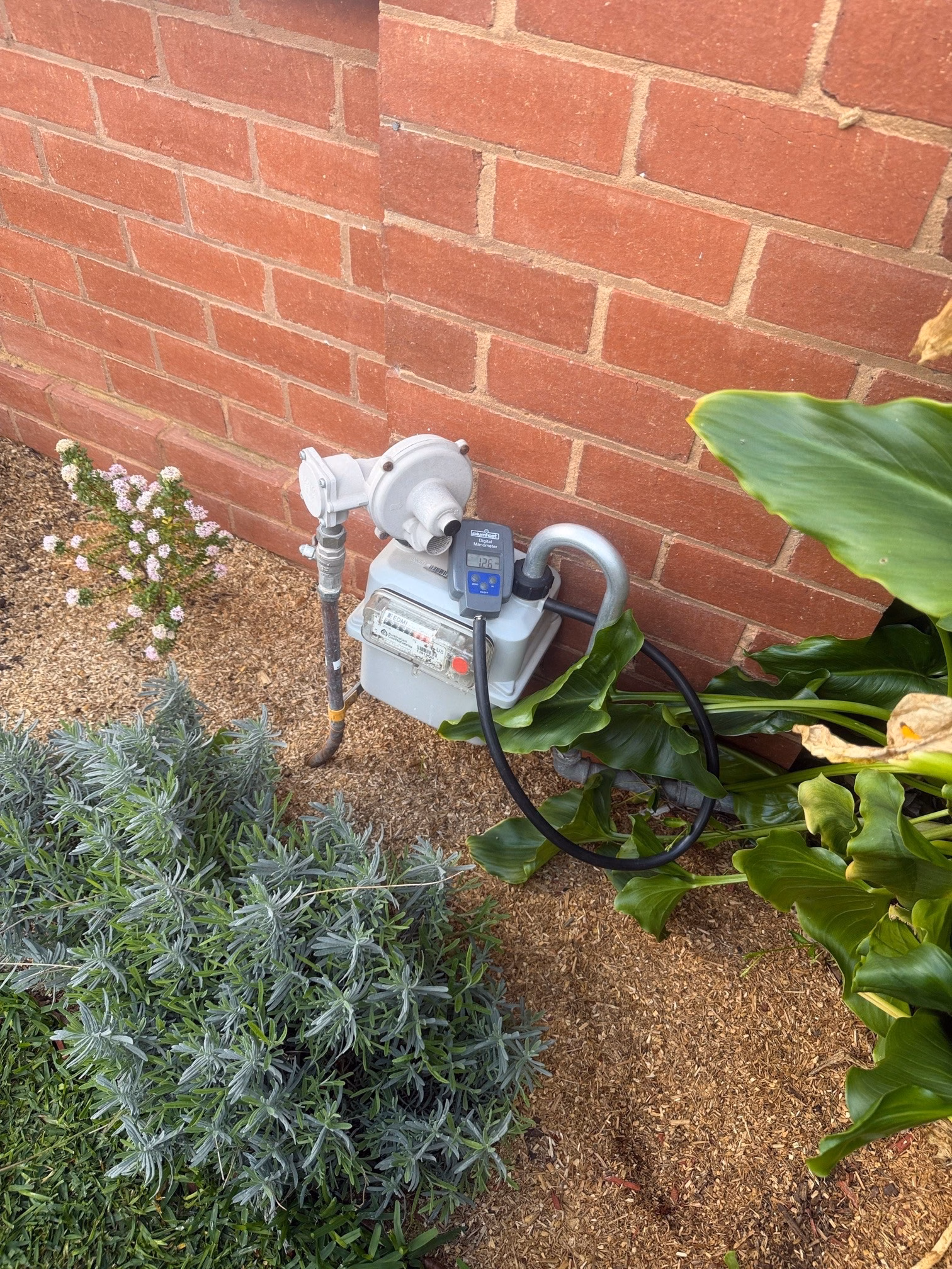 Gas meter connected to a digital manometer during a pressure test